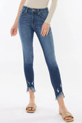 Blue jeans with distressed hem on a white background