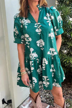 Woman wearing a green floral dress standing outdoors.