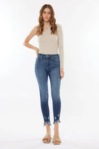 Woman wearing a beige top and blue jeans on a white background