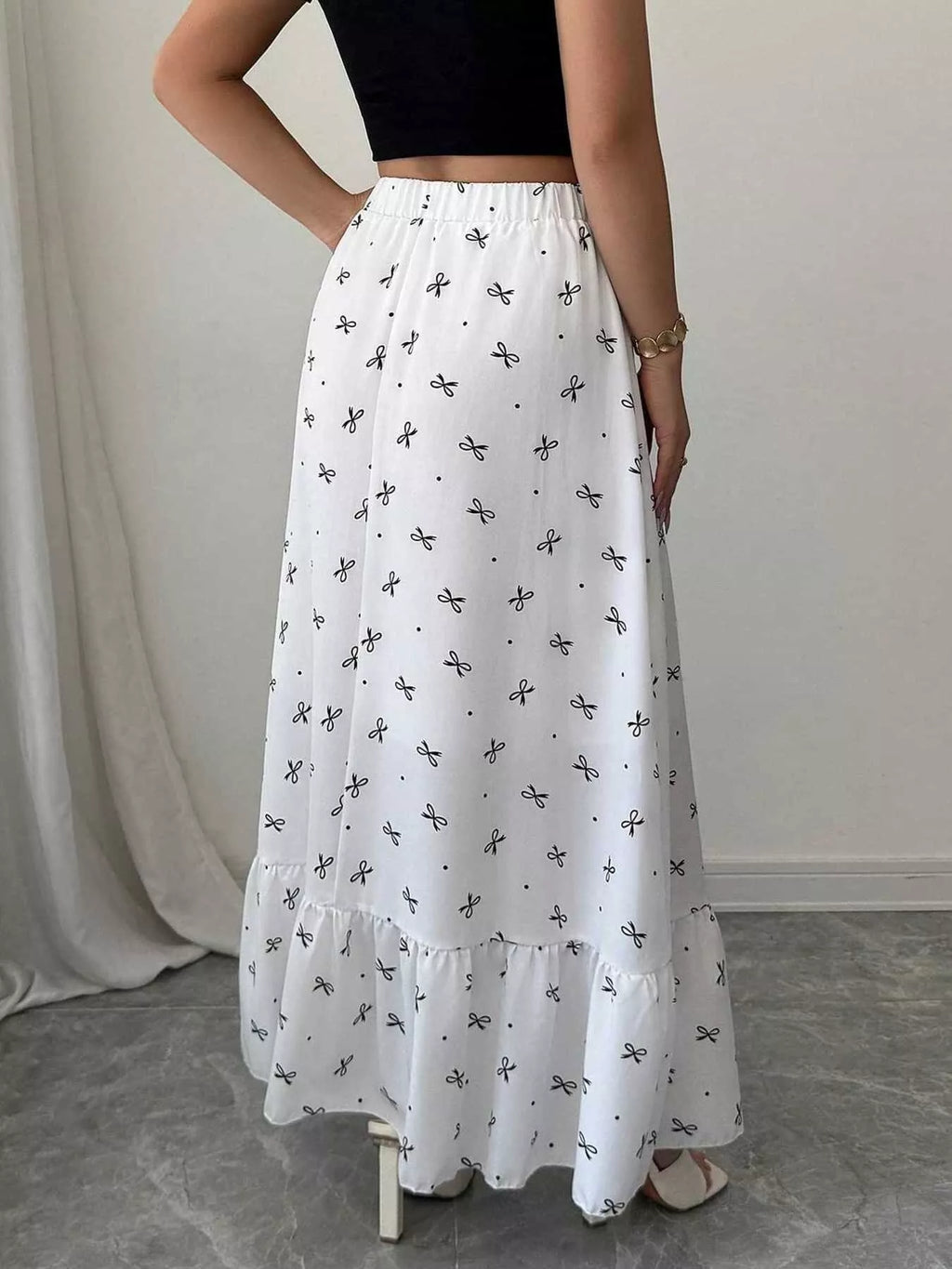 White skirt with black patterns worn by a person on a neutral background