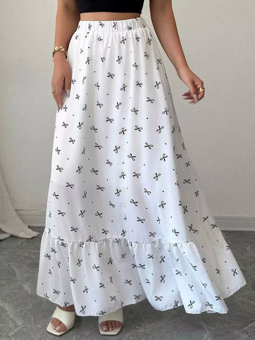 White skirt with black patterns worn by a person on a neutral background