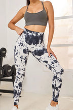 Person wearing tie-dye leggings and sports bra in a gym setting