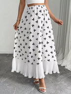 White skirt with black floral pattern worn by a person indoors.