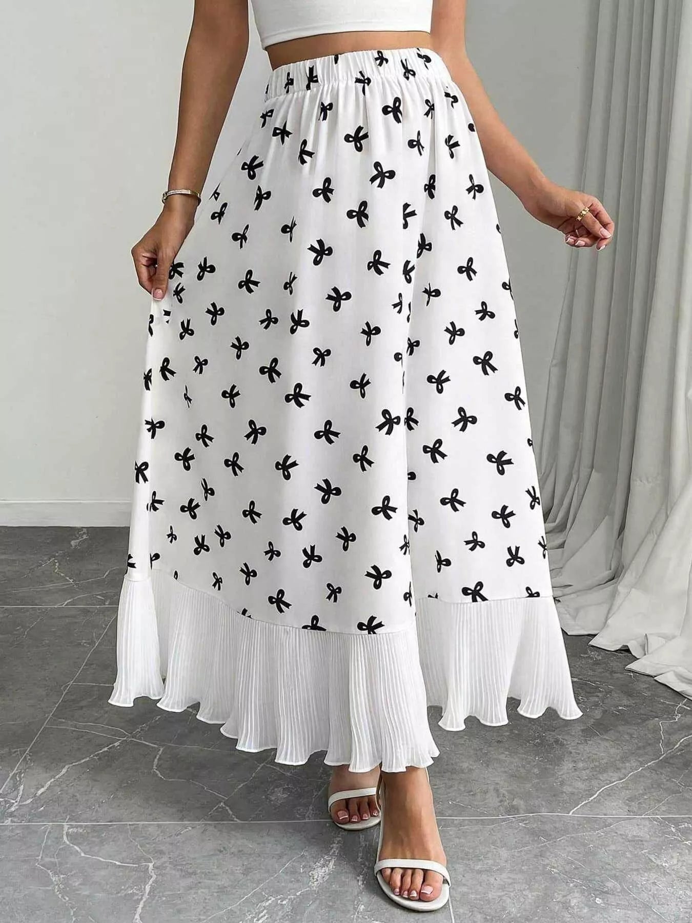 White skirt with black floral pattern worn by a person indoors.