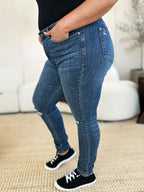 Person wearing blue jeans and black sneakers in a casual setting