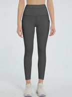 Person wearing dark gray leggings on a light gray background