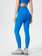 Person wearing blue leggings and a matching top on a white background