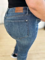 Close-up of blue jeans with a brand label on a neutral background