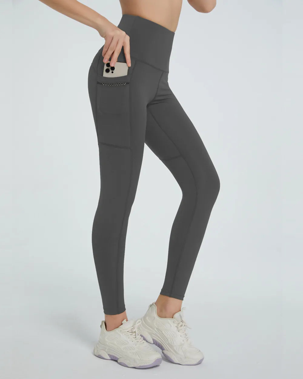 Gray leggings with pockets worn by a person on a white background