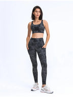 Woman wearing a black tie-dye athletic outfit on a white background