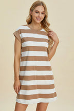Woman wearing a brown and white striped dress on a beige background