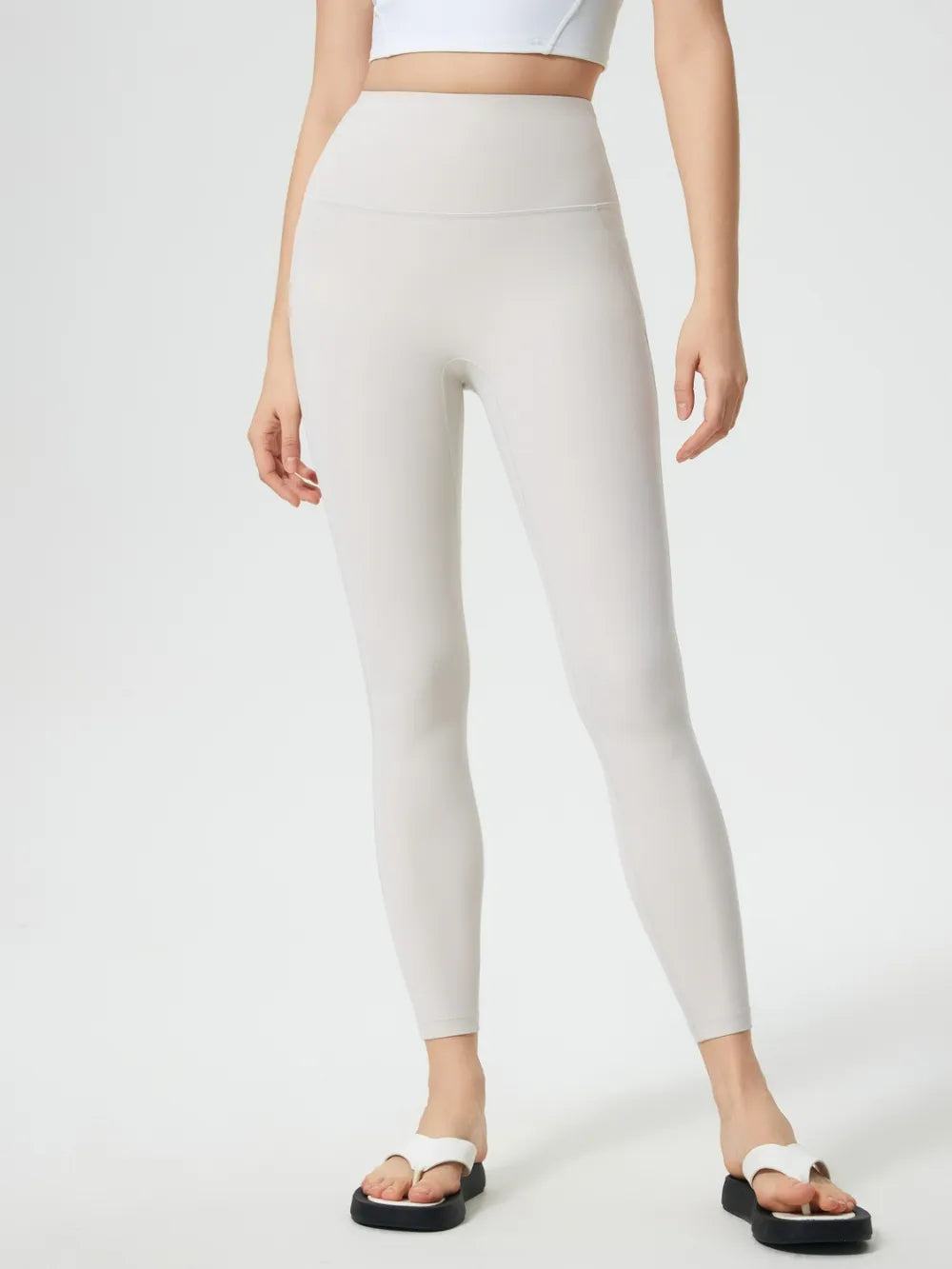 Person wearing beige leggings on a white background