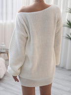Person wearing a white oversized sweater in a bright room with curtains.