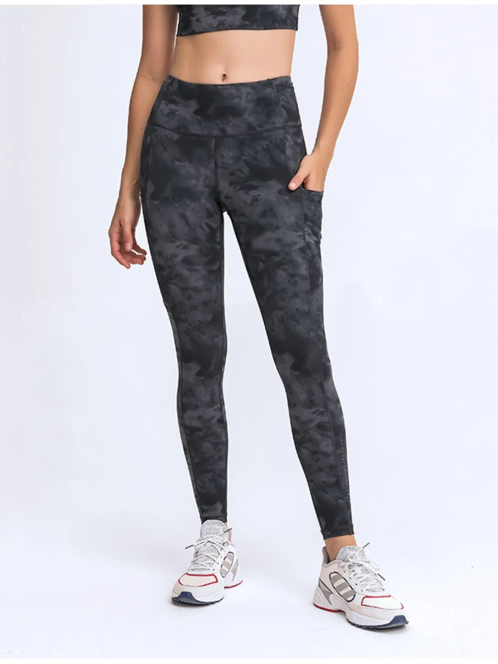 Person wearing black tie-dye leggings on a white background