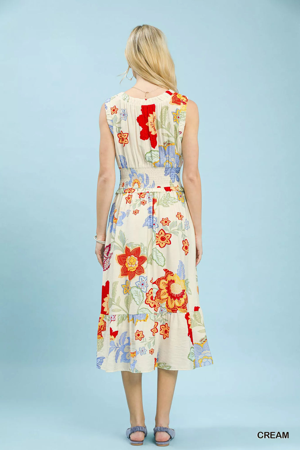 Woman wearing a colorful floral dress against a light blue background