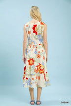Woman wearing a colorful floral dress against a light blue background