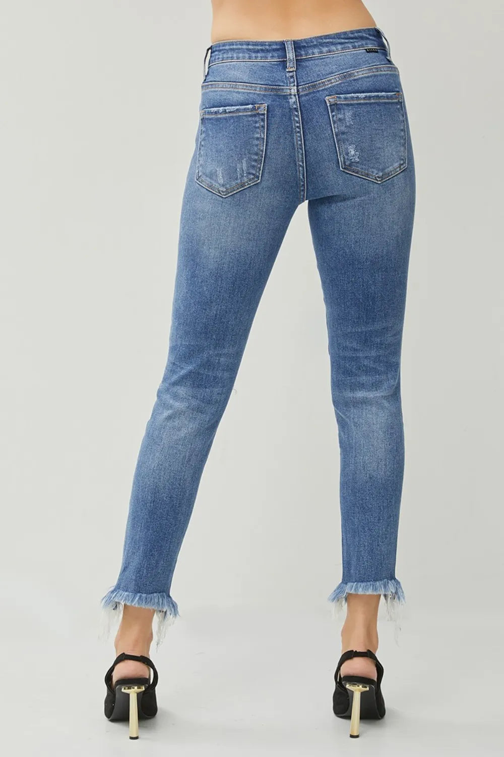 Blue jeans worn by a person on a light gray background