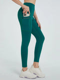 Teal leggings with a pocket feature worn by a person on a white background