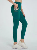 Teal leggings with a pocket feature worn by a person on a white background