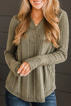 Woman wearing a green ribbed sweater with a blurred background