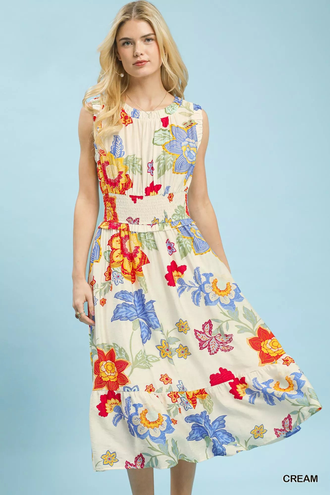Woman wearing a colorful floral dress against a light blue background