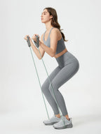 Woman exercising with resistance bands on a white background