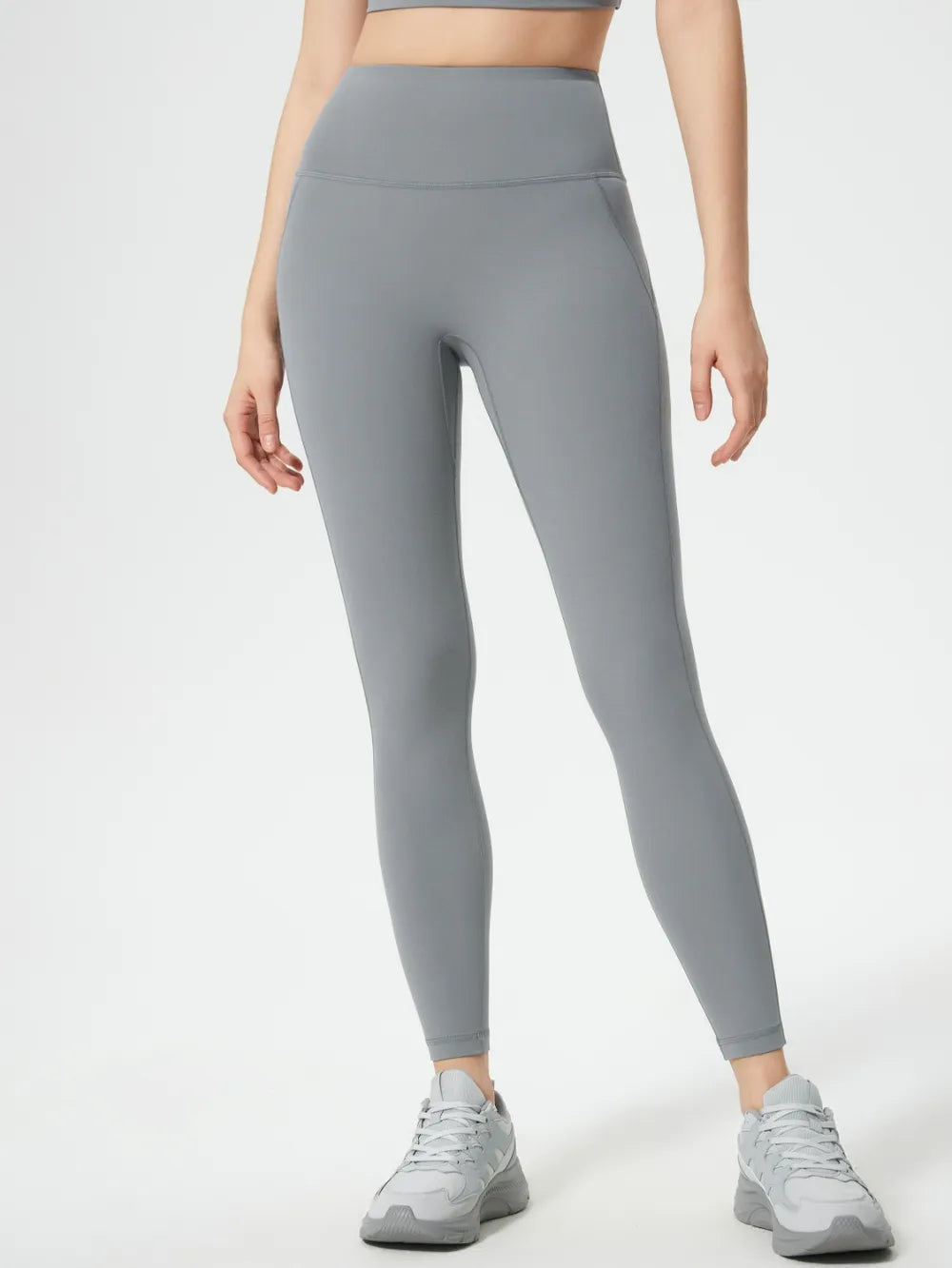 Person wearing gray leggings on a white background