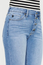 Close-up of light blue jeans with a striped shirt in the background