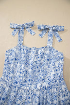 Blue floral dress with bow straps on a beige background