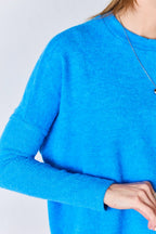 Close-up of a person wearing a blue sweater on a light gray background