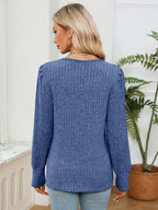 Woman wearing a blue sweater in a room with a plant