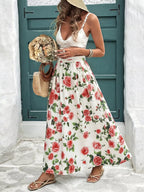 Woman wearing a floral dress and straw hat standing in front of a white wall and green door.