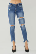 Distressed blue jeans worn by a person on a white background