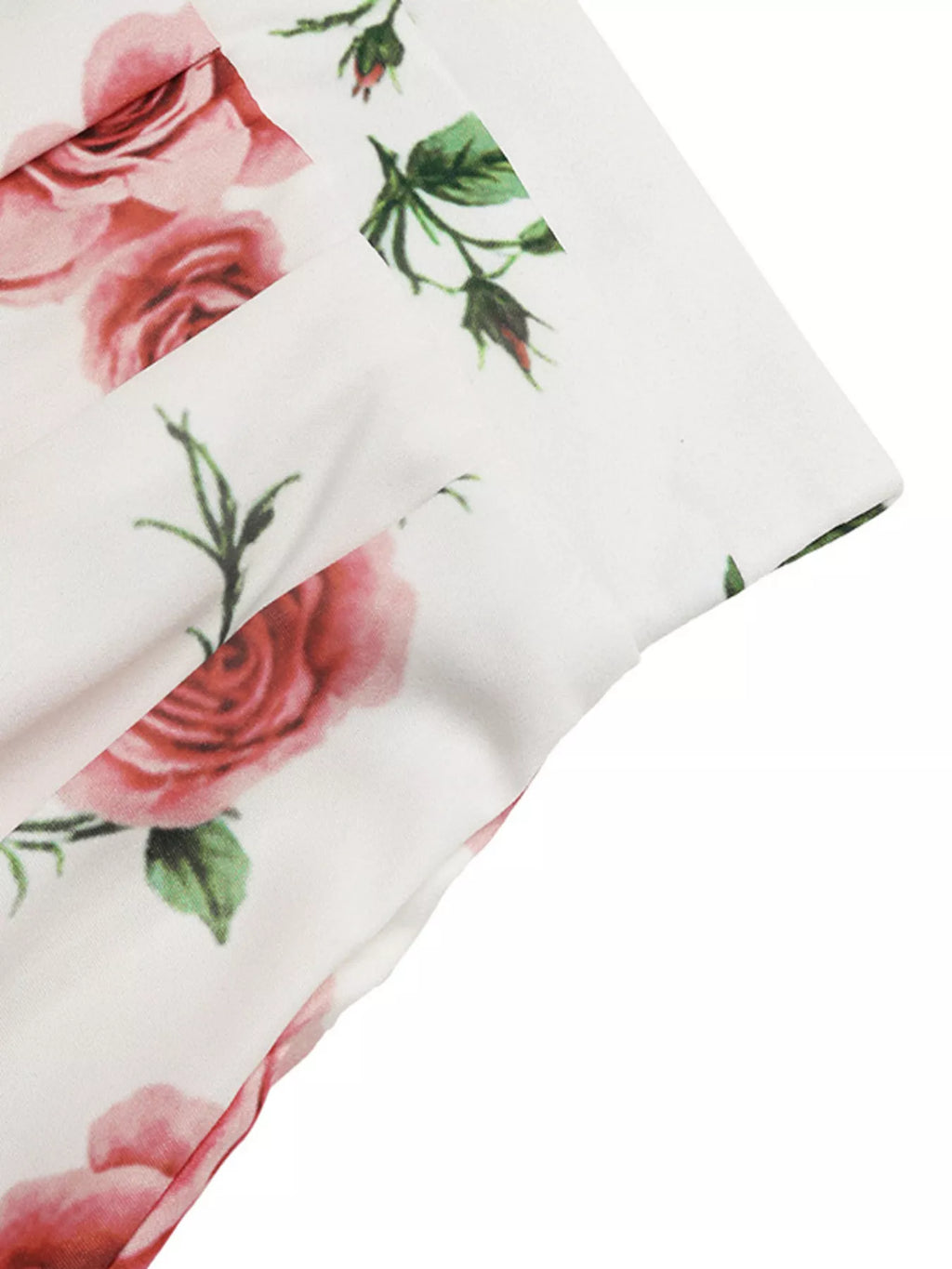 Floral patterned fabric with pink roses and green leaves on a white background