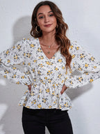 Woman wearing a white floral blouse against a light gray background