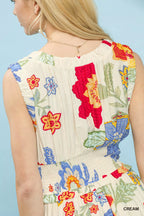 Woman wearing a sleeveless dress with colorful floral embroidery on a light blue background