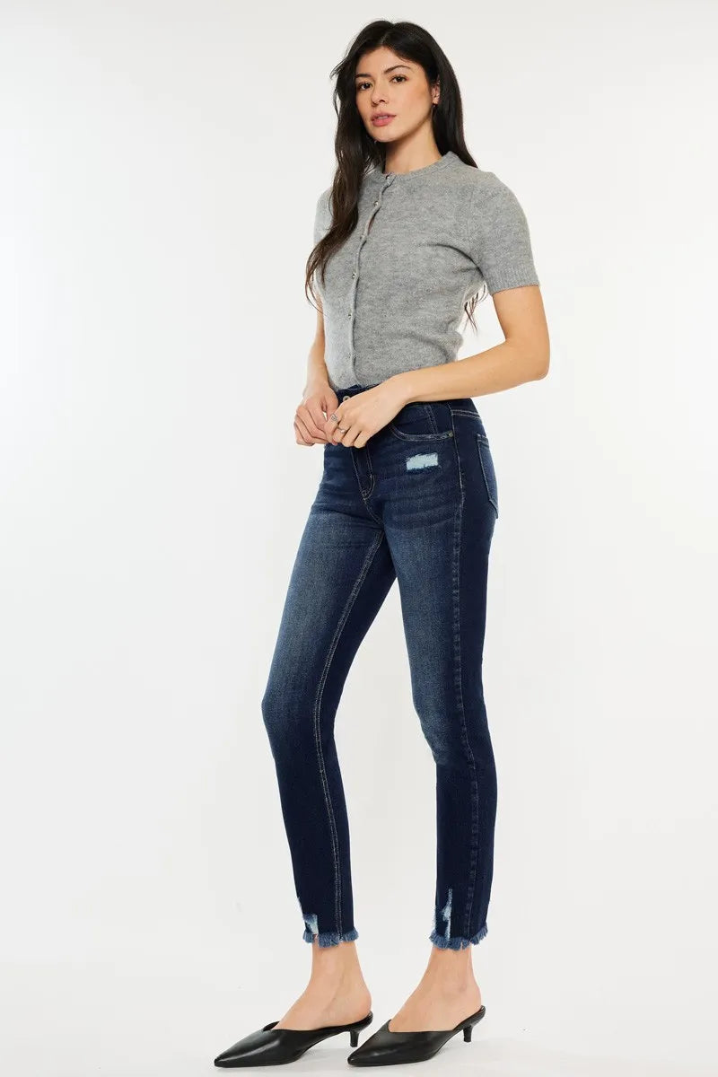 Woman wearing a gray top and dark blue jeans on a white background