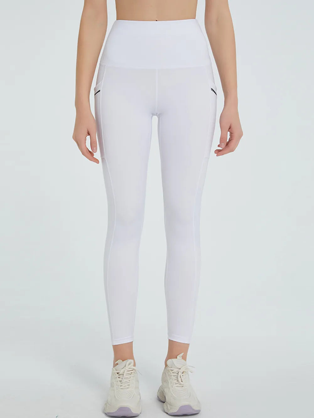Person wearing white leggings on a plain background