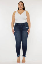 Woman wearing a white top and dark blue jeans on a white background