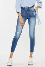 Person wearing blue jeans and a light blue shirt on a white background