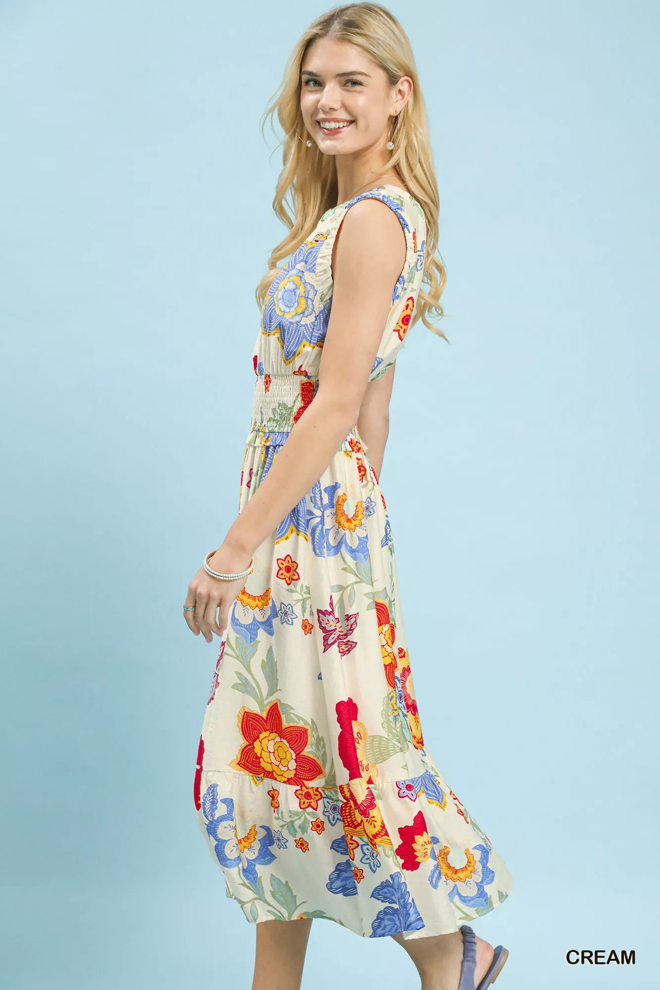 Woman wearing a colorful floral dress on a light blue background