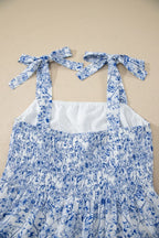 Blue floral dress with white straps on a beige background