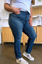 Person wearing blue jeans and white sneakers in a kitchen setting
