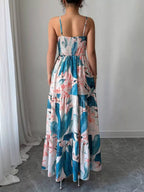Woman wearing a floral dress standing in a room with white curtains and gray floor.