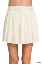 White pleated skirt worn by a person on a white background