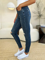 Person wearing blue jeans and white sneakers in a living room setting