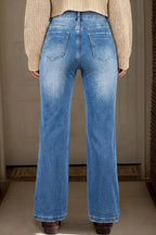 Person wearing blue jeans from behind with a neutral background