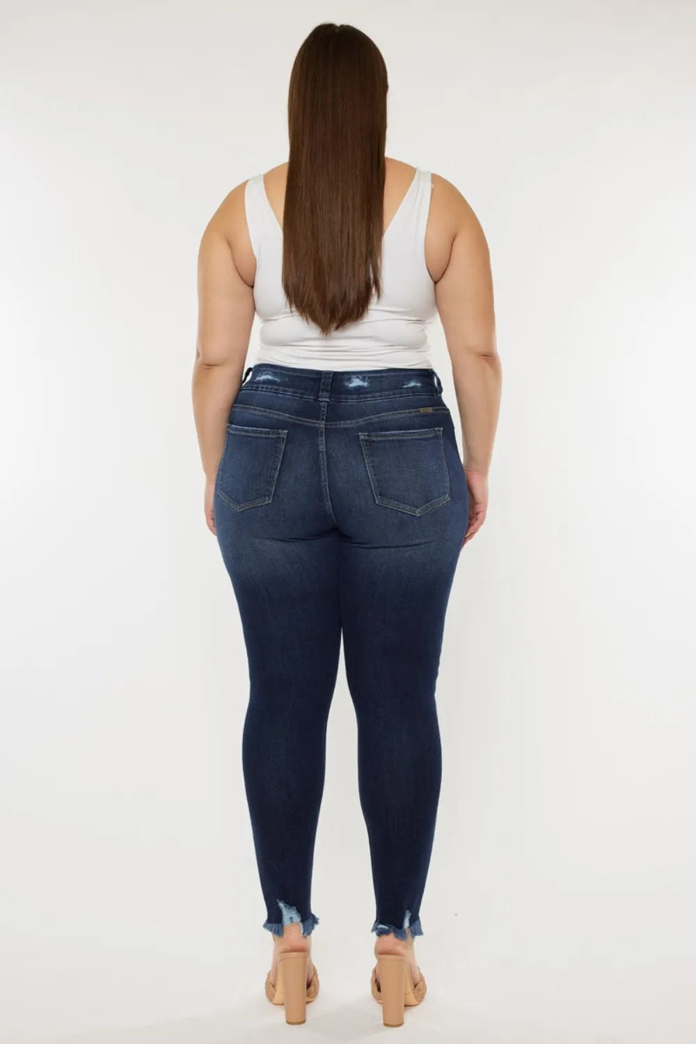 Woman wearing blue jeans and a white top on a white background