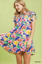 Woman wearing a colorful floral dress against a green background