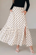 Woman wearing a polka dot skirt with a plain background